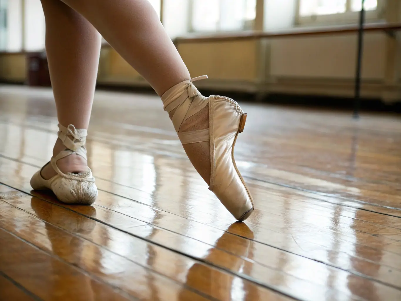 A close-up shot of a dancer's feet gracefully moving across the floor during a traditional dance performance, showcasing precision and elegance.